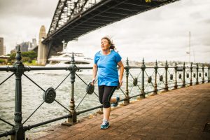 Woman jogging by the bay of Sydney Harbor, Australia